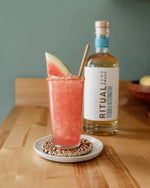 Watermelon cocktail with Ritual Zero Proof tequila alternative bottle in the background.