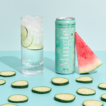 Cucumber Melon Mojito Mocktail can displayed with a tall glass filled with the drink, fresh cucumber slices, and watermelon on a pastel blue backdrop.
