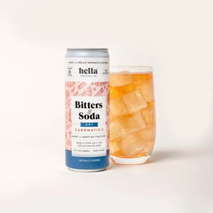 Can of Hella Bitters Soda next to a glass of ice-filled bitters soda on a neutral background.