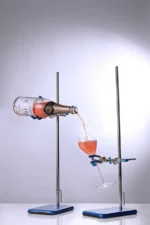 Rosé sparkling wine pouring into a glass using a scientific setup, blending elegance with innovation.